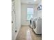 Bright laundry room with tile floor, two machines, shelving, and a window for ventilation and light at 2634 Treeline Dr, Concord, NC 28027