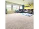 Large carpeted living room with a comfortable sectional sofa, and bright windows overlooking the yard at 2634 Treeline Dr, Concord, NC 28027