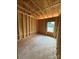 Under construction bedroom with exposed wood frame and window at 2735 Primrose Ave, Charlotte, NC 28208