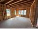 Unfinished bedroom featuring exposed studs, multiple windows, and a concrete floor at 2735 Primrose Ave, Charlotte, NC 28208