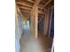 Unfinished entryway featuring exposed studs, concrete floor, and doorway to additional rooms at 2735 Primrose Ave, Charlotte, NC 28208