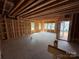 Unfinished living room featuring exposed studs, concrete floor, and an open layout at 2735 Primrose Ave, Charlotte, NC 28208