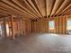 Unfinished living room with stud framing, concrete floor, and exposed ceiling joists at 2735 Primrose Ave, Charlotte, NC 28208