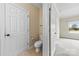 Bathroom with tile flooring, toilet, and a view into an adjacent carpeted room at 2765 Clover Nw Rd, Concord, NC 28027