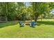 Spacious backyard featuring a fire pit, swing, and mature trees at 3269 Tolley St, Claremont, NC 28610