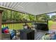 Covered deck with wood railings, comfortable seating, and backyard view at 3269 Tolley St, Claremont, NC 28610