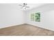 Bright bedroom with light wood flooring, a ceiling fan, and a large window showcasing the lush backyard at 332 Hollingswood Dr, Statesville, NC 28625