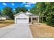 Charming white house with a one-car garage, a cozy front porch, and a long concrete driveway at 332 Hollingswood Dr, Statesville, NC 28625