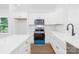 Bright kitchen features white cabinets, stainless steel appliances, subway tile backsplash and an island with white countertop at 332 Hollingswood Dr, Statesville, NC 28625