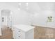 Open-concept living space with white walls, light wood floors, kitchen island, and a view of the entry door at 332 Hollingswood Dr, Statesville, NC 28625