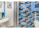 A small blue and grey bathroom includes a sink, brick wall and shower stall at 335 Summit Se Ct, Concord, NC 28025