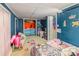 A blue walled bedroom features a wardrobe and a rainbow colored unicorn wall decoration at 335 Summit Se Ct, Concord, NC 28025