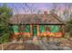 Charming home with a green exterior, brick foundation, and a well-maintained lawn, nestled among mature trees at 335 Summit Se Ct, Concord, NC 28025