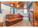 Living room with wood paneled ceiling, and a comfortable brown sofa with brick accent wall at 335 Summit Se Ct, Concord, NC 28025
