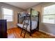 Comfortable bedroom featuring a bunk bed with a ladder, hardwood floors, and natural light from the window at 3413 Fallston Rd, Shelby, NC 28150