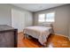A well-lit bedroom features hardwood floors, closet doors, and a soft-colored bedspread for a comfortable space at 3413 Fallston Rd, Shelby, NC 28150