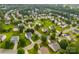 Aerial view shows a dense neighborhood full of lush trees and manicured lawns at 4612 Maple Crest Pl, Harrisburg, NC 28075