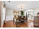 Elegant dining room featuring wood floors, chandelier, and view into the bright, airy kitchen at 4612 Maple Crest Pl, Harrisburg, NC 28075