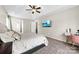 Comfortable main bedroom with a tray ceiling, ceiling fan, and views of the en suite bathroom at 4612 Maple Crest Pl, Harrisburg, NC 28075