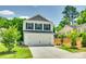 A charming two-story home featuring a two-car garage, classic shutters, and a concrete driveway at 463 W Barr St, Lancaster, SC 29720