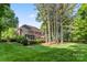 Expansive backyard with mature trees, brick home, and lush green lawn at 5310 Addington Ct, Charlotte, NC 28277