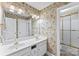 Bathroom featuring a double sink vanity, wallpaper with palm tree theme, and a shower at 5310 Addington Ct, Charlotte, NC 28277