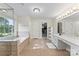 Bright bathroom features a soaking tub under a large window, double vanity, and a separate room sized walk-in closet at 5310 Addington Ct, Charlotte, NC 28277