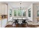 Bright breakfast nook features a custom table, bench seating, large windows, and hardwood floors at 5310 Addington Ct, Charlotte, NC 28277