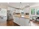 Bright kitchen boasts a stainless fridge, island with granite counters, hardwood floors, and white cabinets at 5310 Addington Ct, Charlotte, NC 28277