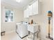 Functional laundry room with a sink, washer, dryer, storage cabinets, and a bright window at 5310 Addington Ct, Charlotte, NC 28277