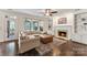 Spacious living room includes a fireplace, large windows, an L-shaped sofa, and hardwood floors at 5310 Addington Ct, Charlotte, NC 28277