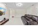 Well-lit living room with a ceiling fan, large TV, and a comfortable leather sofa at 5310 Addington Ct, Charlotte, NC 28277