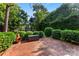 Brick patio with lush landscaping, mature trees, and privacy hedge at 5310 Addington Ct, Charlotte, NC 28277