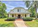 Charming white farmhouse with a classic covered front porch, beautiful shrubs, and manicured lawn at 604 Ferguson Ridge Rd, Gastonia, NC 28052