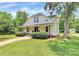 Charming white farmhouse with inviting front porch, beautiful landscaping, and a lush green lawn at 604 Ferguson Ridge Rd, Gastonia, NC 28052