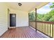 View of covered front porch with wood floors, black door, and wooden railings at 604 Ferguson Ridge Rd, Gastonia, NC 28052