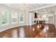 Open-concept room with hardwood floors featuring a kitchen with island and a dining area with large windows and chandelier at 604 Ferguson Ridge Rd, Gastonia, NC 28052