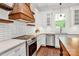 Modern kitchen features stainless appliances, white cabinets, tile backsplash, and wood range hood at 604 Ferguson Ridge Rd, Gastonia, NC 28052