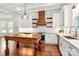 Bright kitchen features white cabinets, stainless appliances, a center island, and stylish wood range hood at 604 Ferguson Ridge Rd, Gastonia, NC 28052