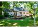 A lush backyard features mature trees, a pergola, a deck, and outdoor seating at 613 E Ridge St, Kings Mountain, NC 28086