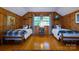 Charming bedroom with hardwood floors, wood paneled walls, and twin beds, ideal for guests at 613 E Ridge St, Kings Mountain, NC 28086