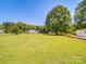 Spacious backyard featuring a well-manicured lawn, mature trees, and an outbuilding at 6416 Wilgrove Mint Hill Rd, Mint Hill, NC 28227