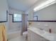Bright bathroom featuring tiled walls, a bath with shower, and a vanity sink area at 6416 Wilgrove Mint Hill Rd, Mint Hill, NC 28227