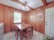 Charming dining room with wood paneling, a window, and a wooden table with seating for four at 6416 Wilgrove Mint Hill Rd, Mint Hill, NC 28227