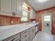 Cozy kitchen featuring wood paneling, white countertops, and white appliances at 6416 Wilgrove Mint Hill Rd, Mint Hill, NC 28227