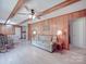 Comfortable living room featuring a ceiling fan, wood paneling, and a view into the kitchen at 6416 Wilgrove Mint Hill Rd, Mint Hill, NC 28227