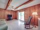 Bright living room with wood paneling, a ceiling fan, sliding glass doors, and a rocking chair at 6416 Wilgrove Mint Hill Rd, Mint Hill, NC 28227