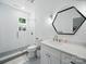 Bright bathroom features large vanity, hexagon mirror, and tiled walk-in shower at 708 Cross Trail Dr, Charlotte, NC 28204