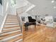 Bright entryway featuring hardwood floors, a grand staircase, a piano, and a view into the open living room with a fireplace at 708 Cross Trail Dr, Charlotte, NC 28204