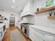 Modern kitchen with stainless steel appliances, white cabinets, quartz countertops, and wood shelving, creating a functional and stylish space at 708 Cross Trail Dr, Charlotte, NC 28204
